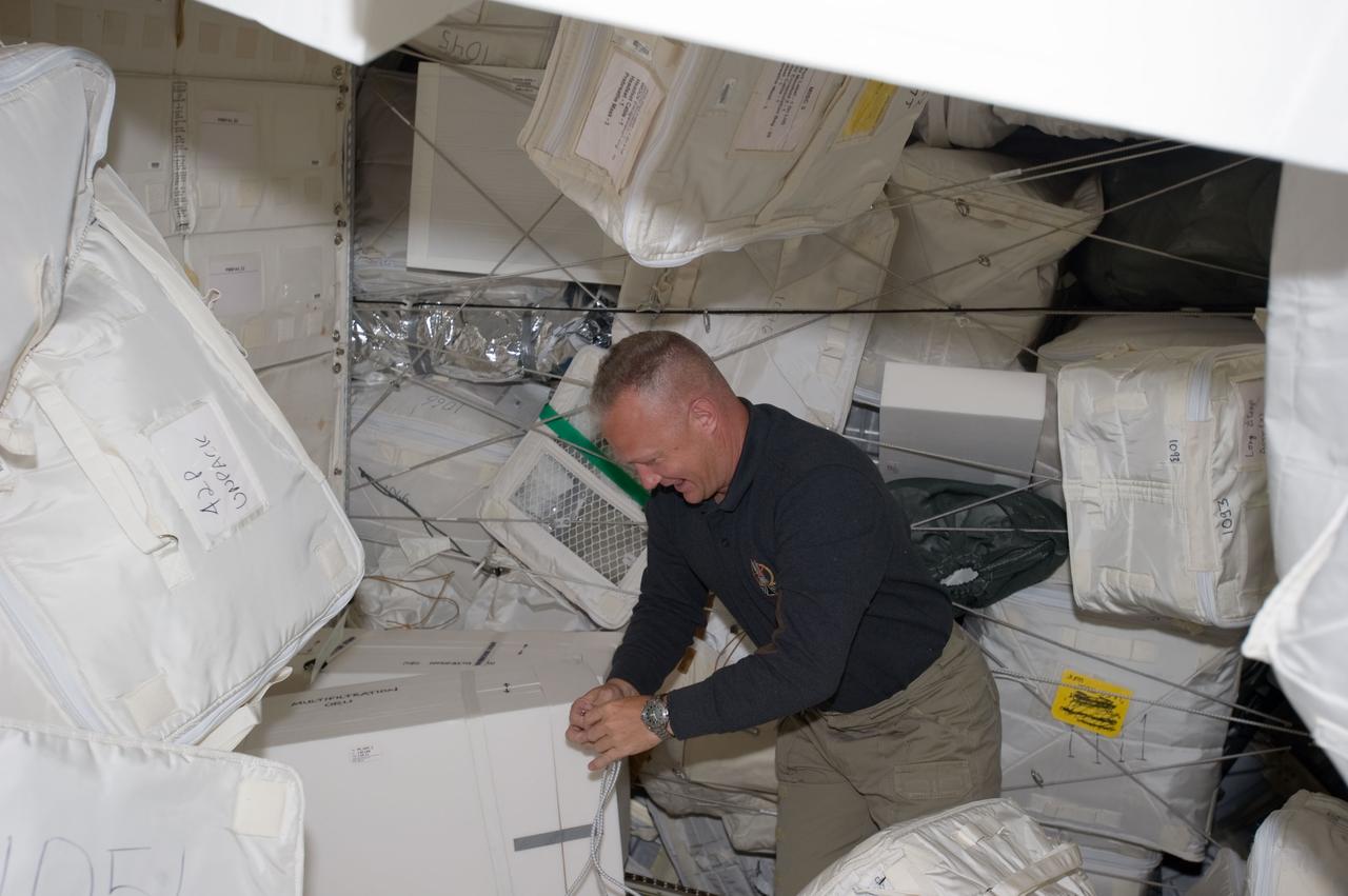 S135-E-007439 (11 July 2011) --- NASA astronaut Doug Hurley, STS-135 pilot, moves around supplies and equipment in the Leonardo Permanent Multipurpose Module (PMM) during the fourth day of flight for Atlantis' four person crew. This module is a component that joined the International Space Station complex after it was flown into space aboard the space shuttle Discovery on STS-133. Photo credit: NASA