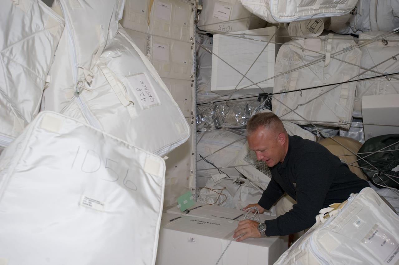 S135-E-007441 (11 July 2011) --- NASA astronaut Doug Hurley, STS-135 pilot, moves around supplies and equipment in the Leonardo Permanent Multipurpose Module (PMM) during the fourth day of flight for Atlantis' four person crew. This module is a component that joined the International Space Station complex after it was flown into space aboard the space shuttle Discovery on STS-133. Photo credit: NASA