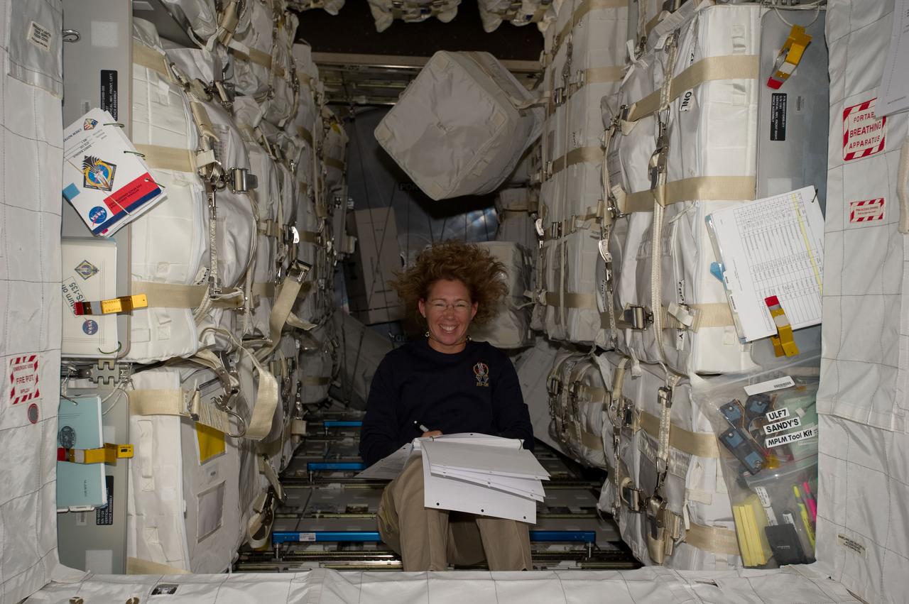 S135-E-007478  (12 July 2011) --- Surrounded by supplies and spare parts in the Raffaello multi-purpose logistics module, NASA astronaut Sandy Magnus continues her role as "load master" for the joint activities of the Atlantis and International Space Station crews. The tons of items are for use and consumption for the station and its crews. Raffaello was transported up to the station by Magnus and her three crewmates aboard the space shuttle. Photo credit: NASA