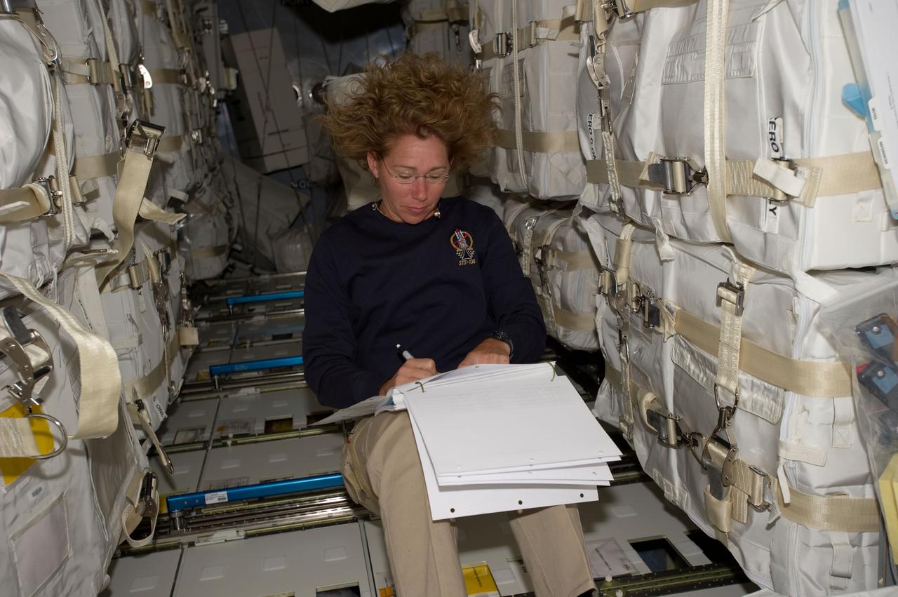 S135-E-007479  (12 July 2011) --- Surrounded by supplies and spare parts in the Raffaello multi-purpose logistics module, NASA astronaut Sandy Magnus continues her role as "load master" for the joint activities of the Atlantis and International Space Station crews. The tons of items are for use and consumption for the station and its crews. Raffaello was transported up to the station by Magnus and her three crewmates aboard the space shuttle. Photo credit: NASA