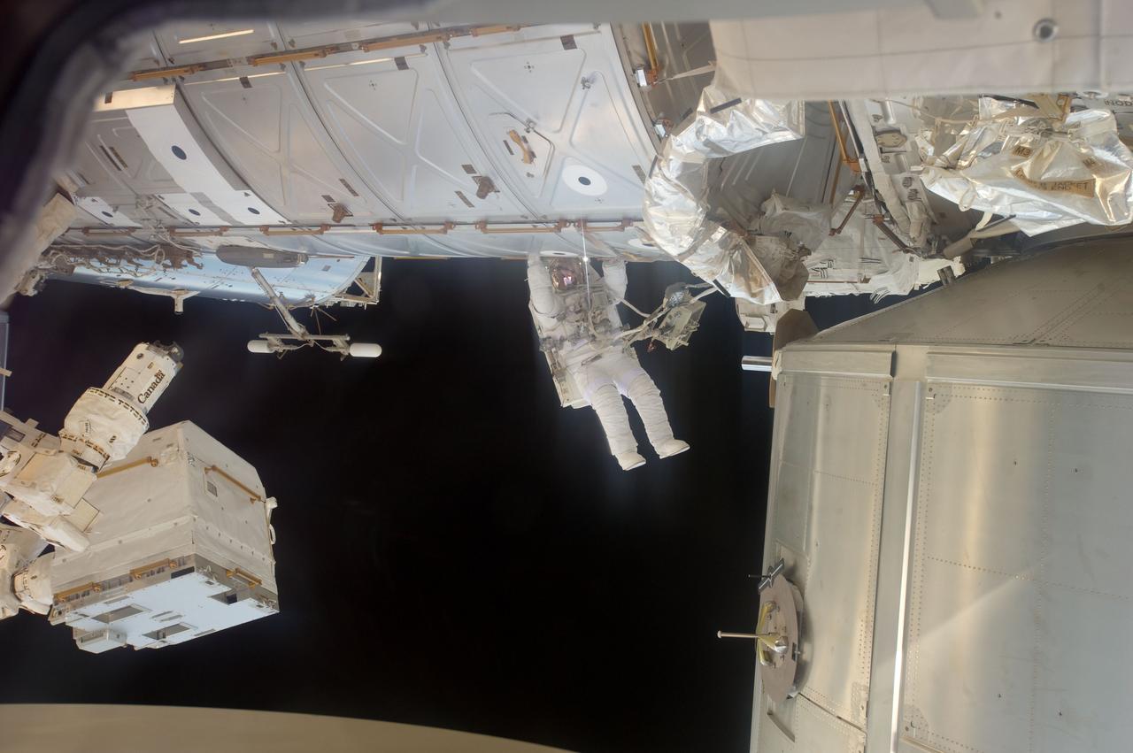 S135-E-007582 (12 July 2011) --- With the help of his hands and a tether, NASA astronaut Ron Garan hangs from the U.S. lab or Destiny during a July 12 extravehicular activity (EVA) that lasted just over six and a half hours. Out of frame is astronaut Mike Fossum. Photo credit: NASA