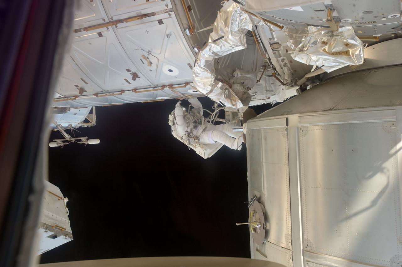 S135-E-007585 (12 July 2011) --- With the help of his hands and a tether, NASA astronaut Ron Garan hangs from the U.S. lab or Destiny during a July 12 extravehicular activity (EVA) that lasted just over six and a half hours. Out of frame is astronaut Mike Fossum. Photo credit: NASA