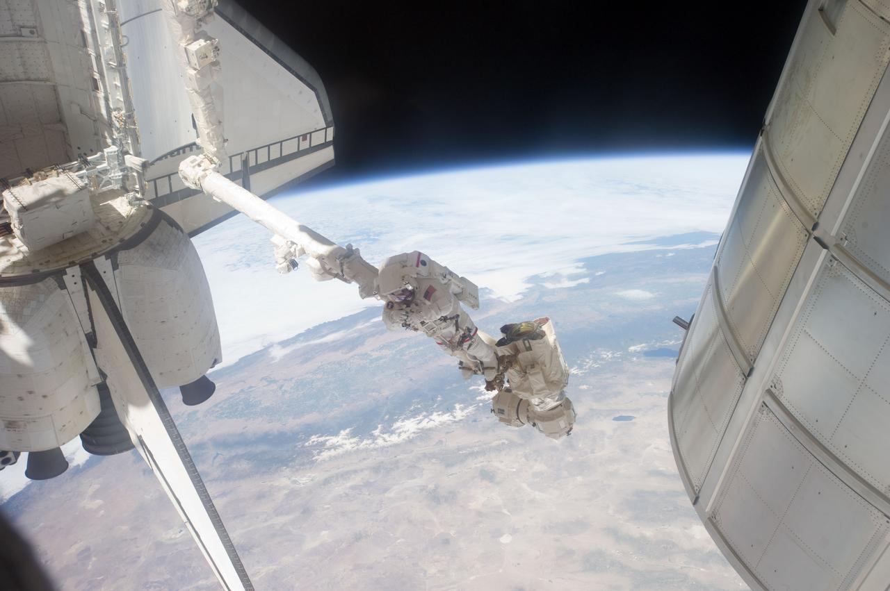 S135-E-007614 (12 July 2011) --- Suspended in a very unique position on the end of the space station remote manipulator system or Canadarm2, NASA astronaut Mike Fossum takes a picture during a July 12 spacewalk. Fossum and NASA astronaut Ron Garan spent just a little over six and a half hours on their various tasks. Photo credit: NASA