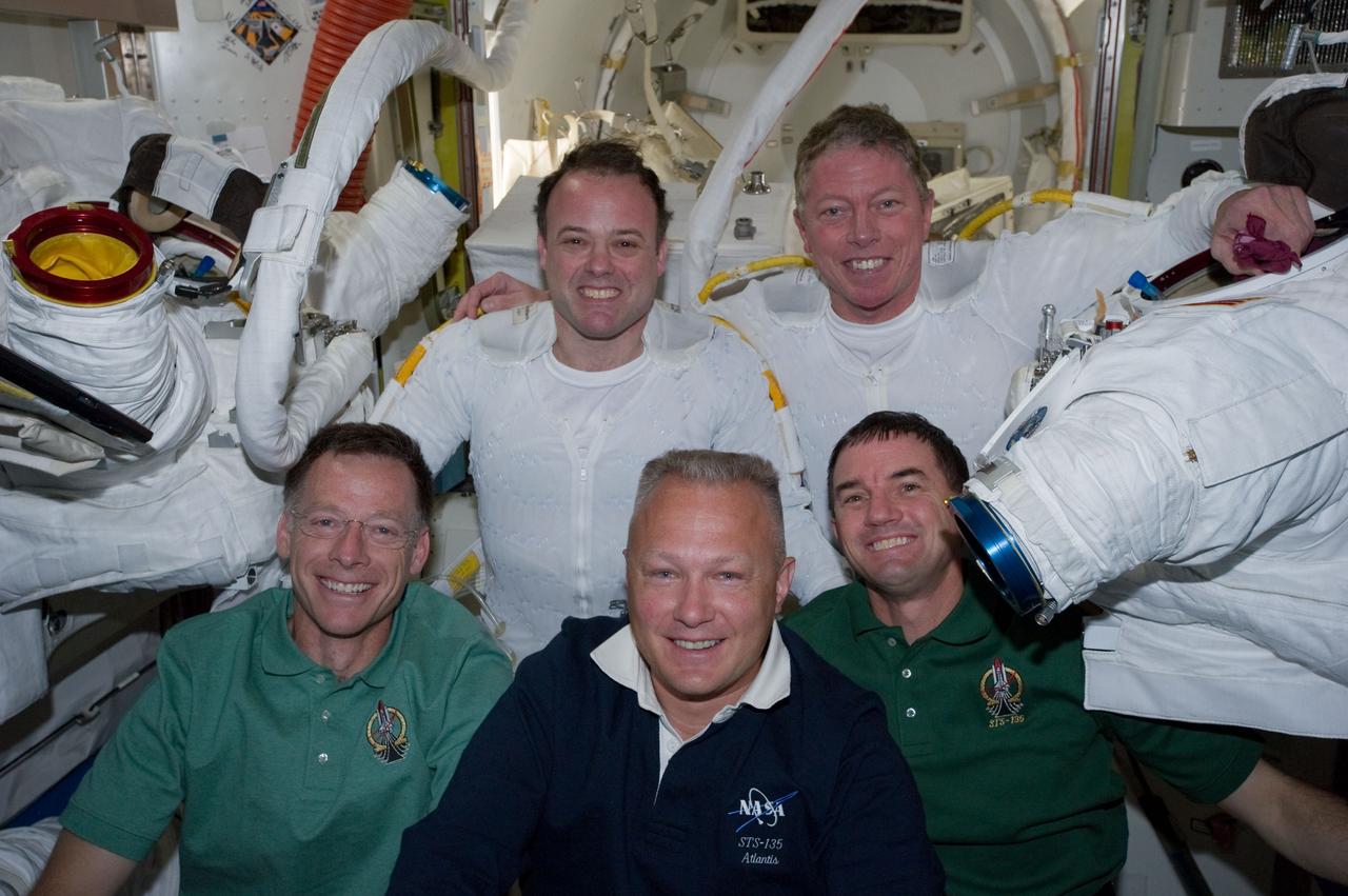 S135-E-007632 (12 July 2011) --- Following the six-hour, 31-minute spacewalk of NASA astronauts Ron Garan (top left) and Mike Fossum (top right), five members of the joint shuttle-station crew pose for photographs in the Quest airlock of the International Space Station. Remaining inside but contributing greatly to the outside duo were, from left front, NASA astronauts Chris Ferguson, STS-135 commander, Doug Hurley, pilot, and Rex Walheim, mission specialist. Garan and Fossum are flight engineers for the station's Expedition 28 crew. Photo credit: NASA