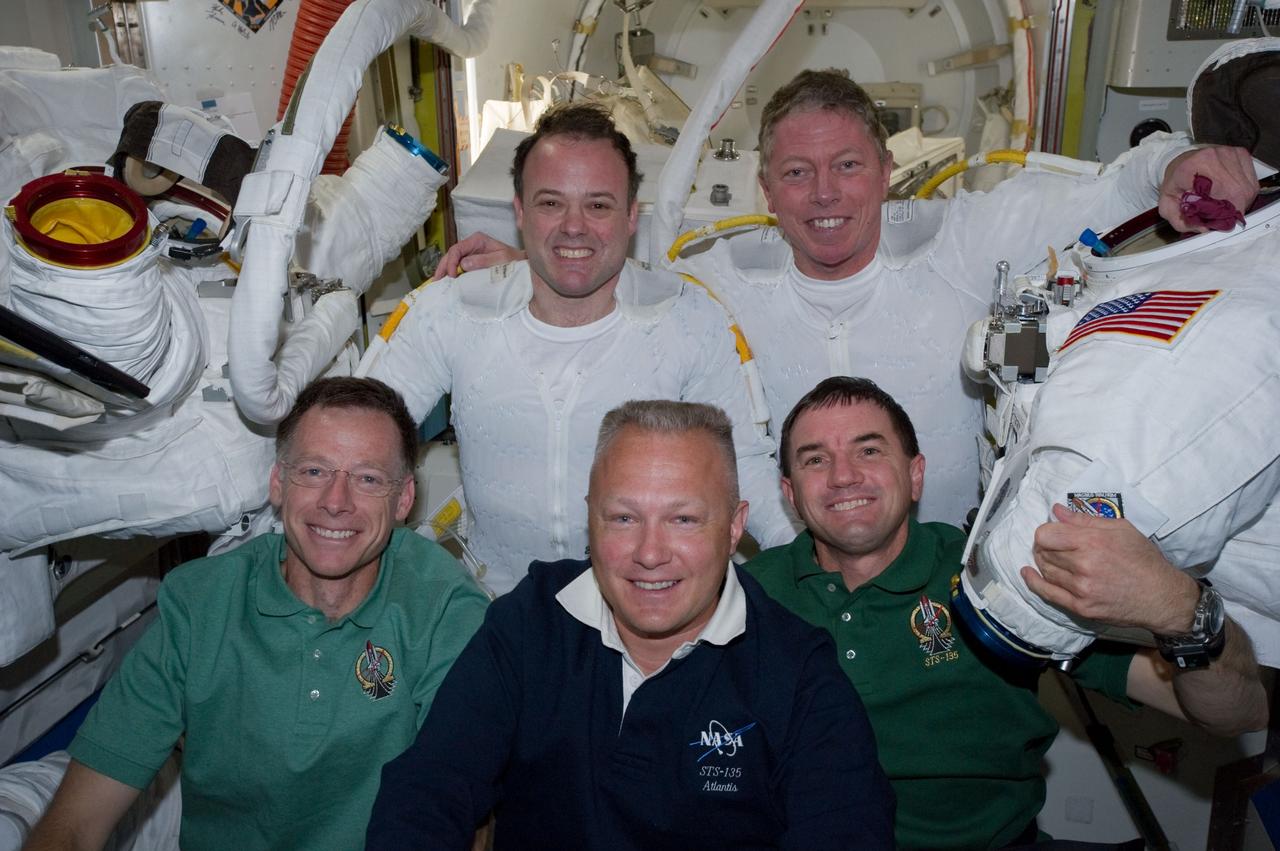 S135-E-007633(12 July 2011) --- Following the six-hour, 31-minute spacewalk of NASA astronauts Ron Garan (top left) and Mike Fossum (top right), five members of the joint shuttle-station crew pose for photographs in the Quest airlock of the International Space Station. Remaining inside but contributing greatly to the outside duo were, from left front, NASA astronauts Chris Ferguson, STS-135 commander, Doug Hurley, pilot, and Rex Walheim, mission specialist. Garan and Fossum are flight engineers for the station's Expedition 28 crew. Photo credit: NASA