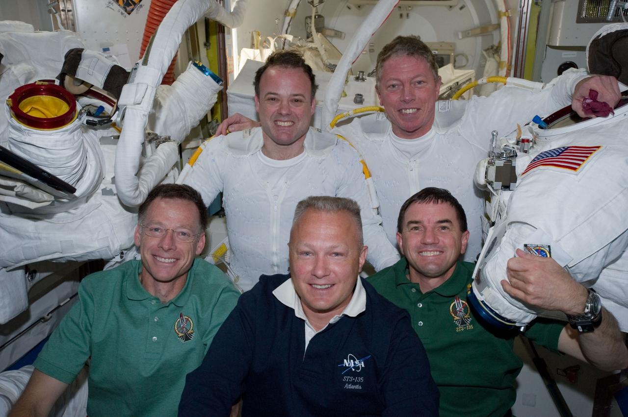 S135-E-007634 (12 July 2011) --- Following the six-hour, 31-minute spacewalk of NASA astronauts Ron Garan (top left) and Mike Fossum (top right), five members of the joint shuttle-station crew pose for photographs in the Quest airlock of the International Space Station. Remaining inside but contributing greatly to the outside duo were, from left front, NASA astronauts Chris Ferguson, STS-135 commander, Doug Hurley, pilot, and Rex Walheim, mission specialist. Garan and Fossum are flight engineers for the station's Expedition 28 crew. Photo credit: NASA