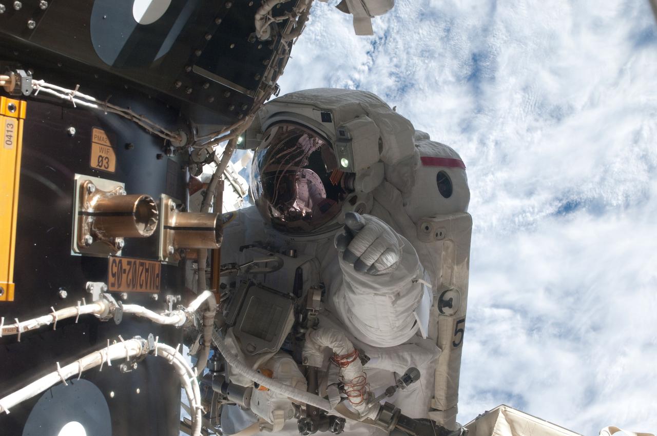 S135-E-007655 (12 July 2011) --- NASA astronaut Mike Fossum, Expedition 28 flight engineer, waits at an International Space Station's pressurized mating adapter (PMA-2) docked to the space shuttle Atlantis, as the station's robotic system moves the failed pump module (out of frame) over to the spacewalking astronaut and the shuttle's cargo bay. Fossum and crewmate Ron Garan sent six hours and 31 minutes on their July 12 spacewalk. Photo credit: NASA