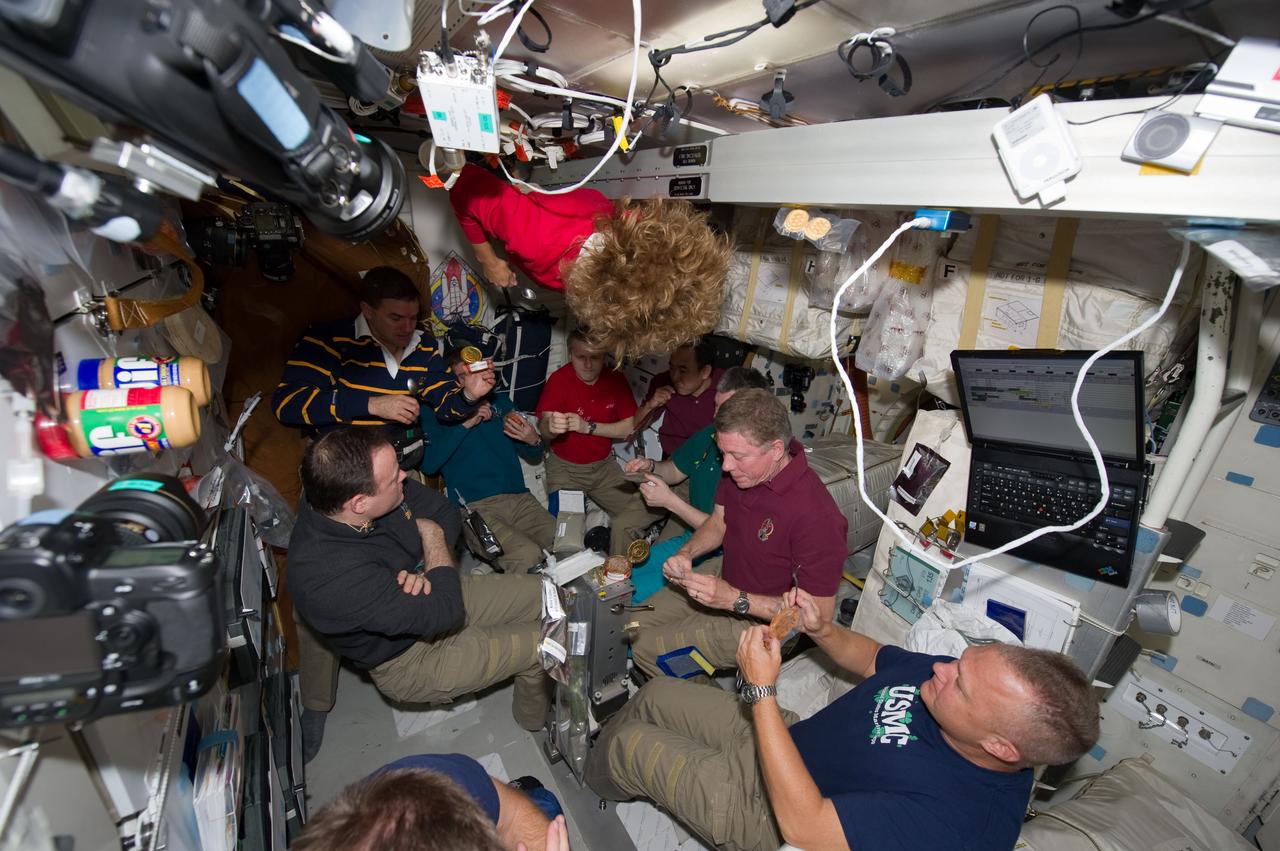 S135-E-007791(14 July 2011) --- Seven  astronauts – six from NASA and one from the Japan Aerospace Exploration Agency (JAXA) – and three Russian  cosmonauts participate on July 14, 2011 in a special meal on the Space Shuttle Atlantis' middeck.  One of the final meals shared between shuttle and station crews has been called  “The  All-American Meal.”   The STS-135 crew consists of NASA astronauts Chris Ferguson, Doug Hurley, Sandy Magnus and Rex Walheim; the  Expedition 28 or International Space Station crew members are  JAXA astronaut Satoshi Furukawa, NASA astronauts Ron Garan and Mike Fossum, and Russian cosmonauts Andrey  Borisenko, Alexander  Samokutyaev  and  Sergei Volkov.  Note: Ferguson is barely in the frame at bottom foreground.  Photo credit: NASA 