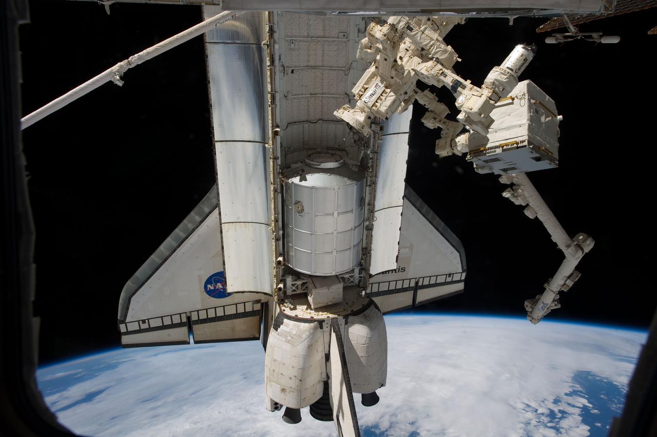 S135-E-009332 (18 July 2011) --- This is a view of the space shuttle Atlantis and its Raffaello multi-purpose logistics module during the final day of being docked with the International Space Station. The object connected to the station at right in the grasp of Dextre, a robot hand, is the  Cargo Transport Container-2 (CTC-2) which was delivered by JAXA's HTV-2 vehicle earlier in the year. Photo credit: NASA