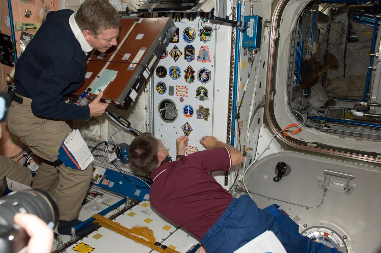 S135-E-009465 (18 July 2011) --- Inside the International Space Station's Node 1 or Unity, NASA astronaut Chris Ferguson, STS-135 commander, adds his mission's decal as the final piece of the collection of shuttle crew insignias. NASA astronaut Mike Fossum, Expedition 28 flight engineer, looks on. Photo credit: NASA
