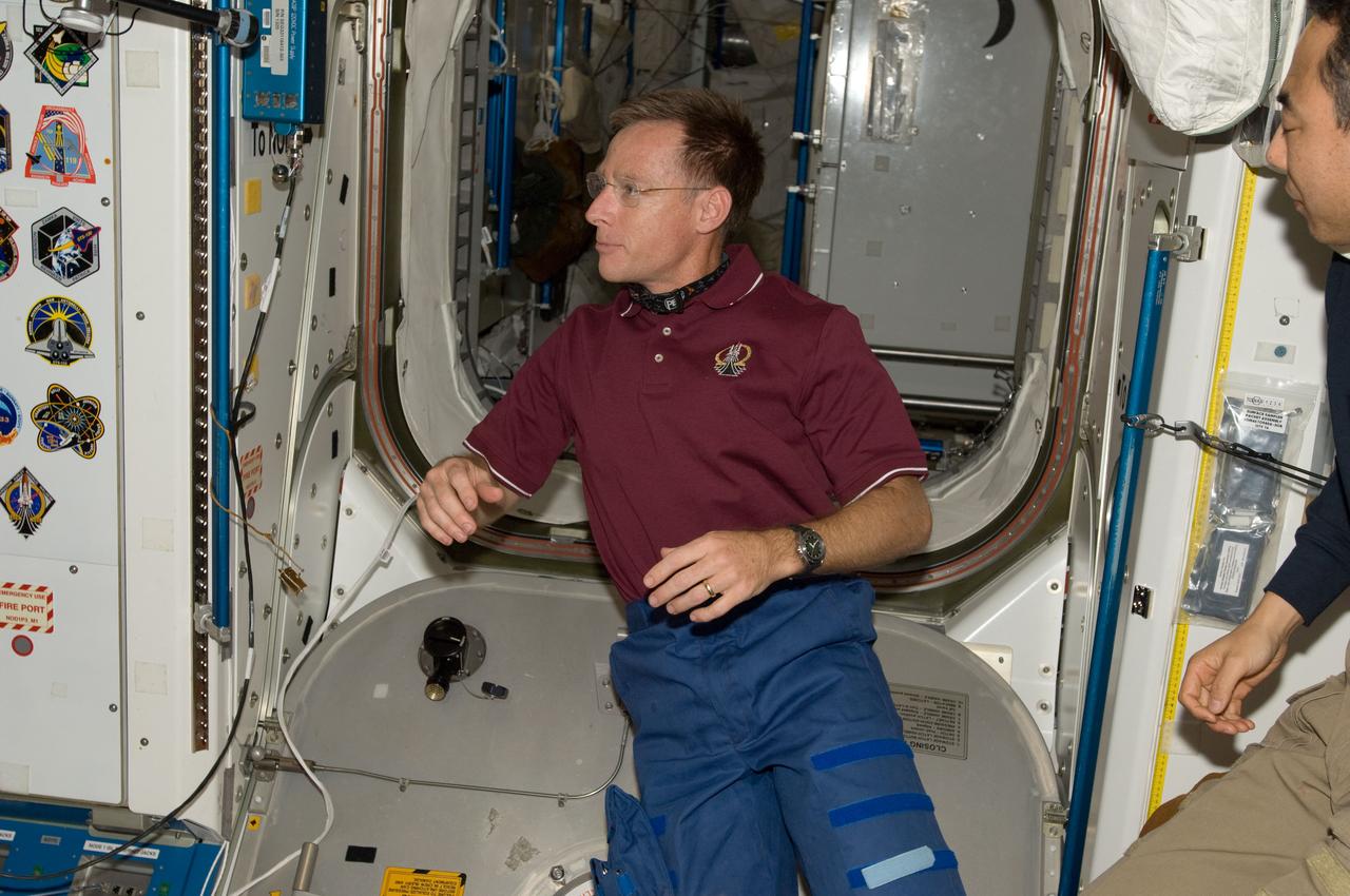 S135-E-009479 (18 July 2011) --- Inside the International Space Station's Node 1 or Unity, NASA astronaut Chris Ferguson, STS-135 commander, prepares to add his mission's decal as the final piece of the collection of shuttle crew insignias, partially visible at left. Photo credit: NASA