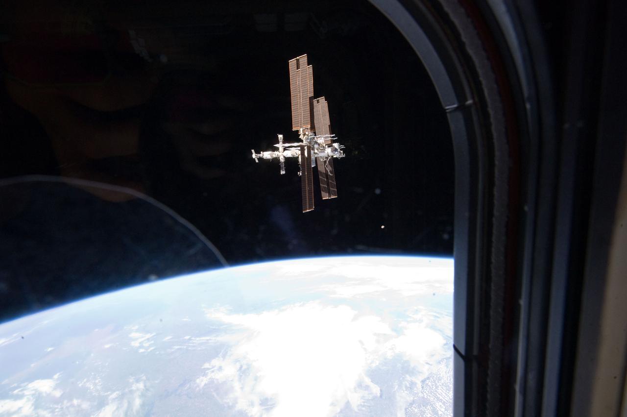 S135-E-010788(19 July 2011) --- This picture of the International Space Station was photographed from the space shuttle Atlantis as the orbiting complex and the shuttle performed their relative separation in the early hours of July 19, 2011. The glass reflects very minutely some of the shuttle in-cabin activity and crew. Onboard the station were Russian cosmonauts Andrey Borisenko, commander; Sergei Volkov and Alexander Samokutyaev, both flight engineers; Japan Aerospace Exploration astronaut Satoshi Furukawa, and NASA astronauts Mike Fossum and Ron Garan, all flight engineers. Onboard the shuttle were NASA astronauts Chris Ferguson, commander; Doug Hurley, pilot; and Sandy Magnus and Rex Walheim, both mission specialists. Photo credit: NASA
