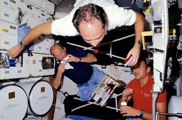 STS-26 crewmembers experiment with microgravity and eat on middeck