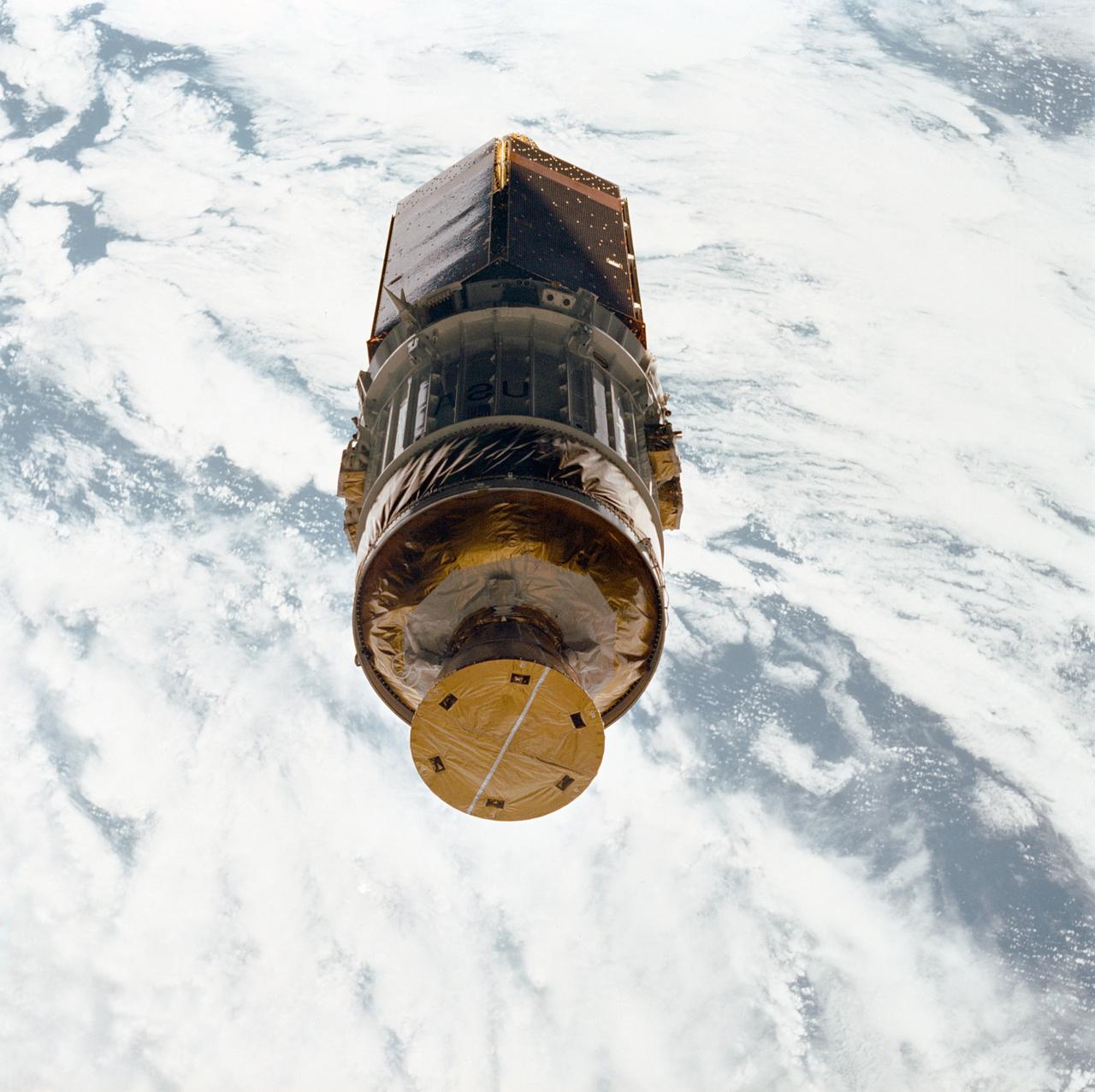 STS026-31-071 (3 Oct 1988) --- After deployment from Discovery, Orbiter Vehicle (OV) 103, the inertial upper stage (IUS) with the tracking and data relay satellite C (TDRS-C) drifts above the cloud-covered Earth surface. TDRS-C, in stowed configuration (solar array panels visible), is mounted atop the IUS with the interstage and solid rocket motor and nozzle seen in the foreground.