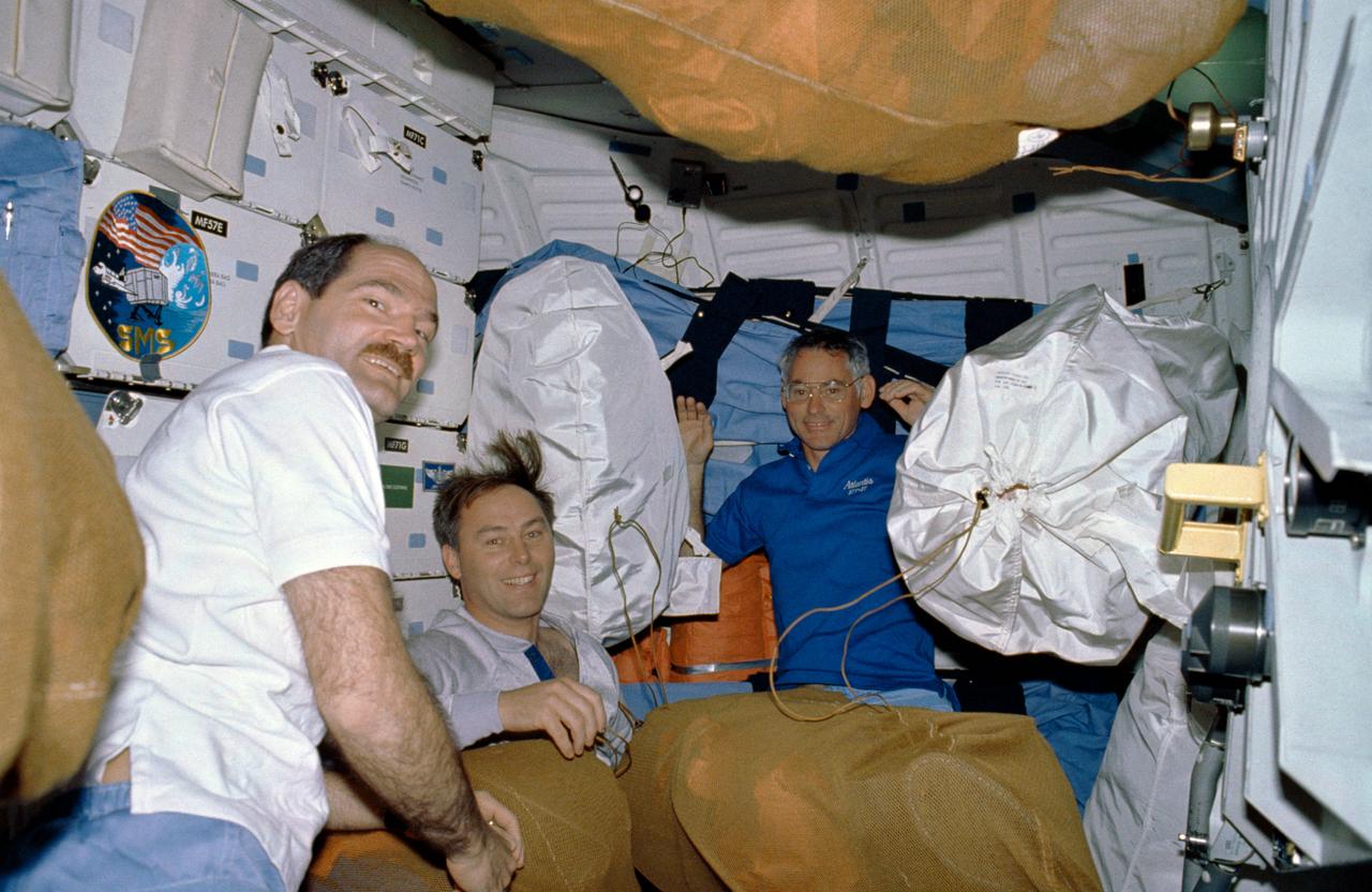 STS027-10-003 (2-6 Dec. 1988) --- From the left, astronauts Guy S. Gardner, STS-27 pilot, along with Jerry L. Ross and Richard M. (Mike) Mullane, both mission specialists, take a break from moving gear and equipment on the middeck of the Earth-orbiting space shuttle Atlantis. Photo credit: NASA