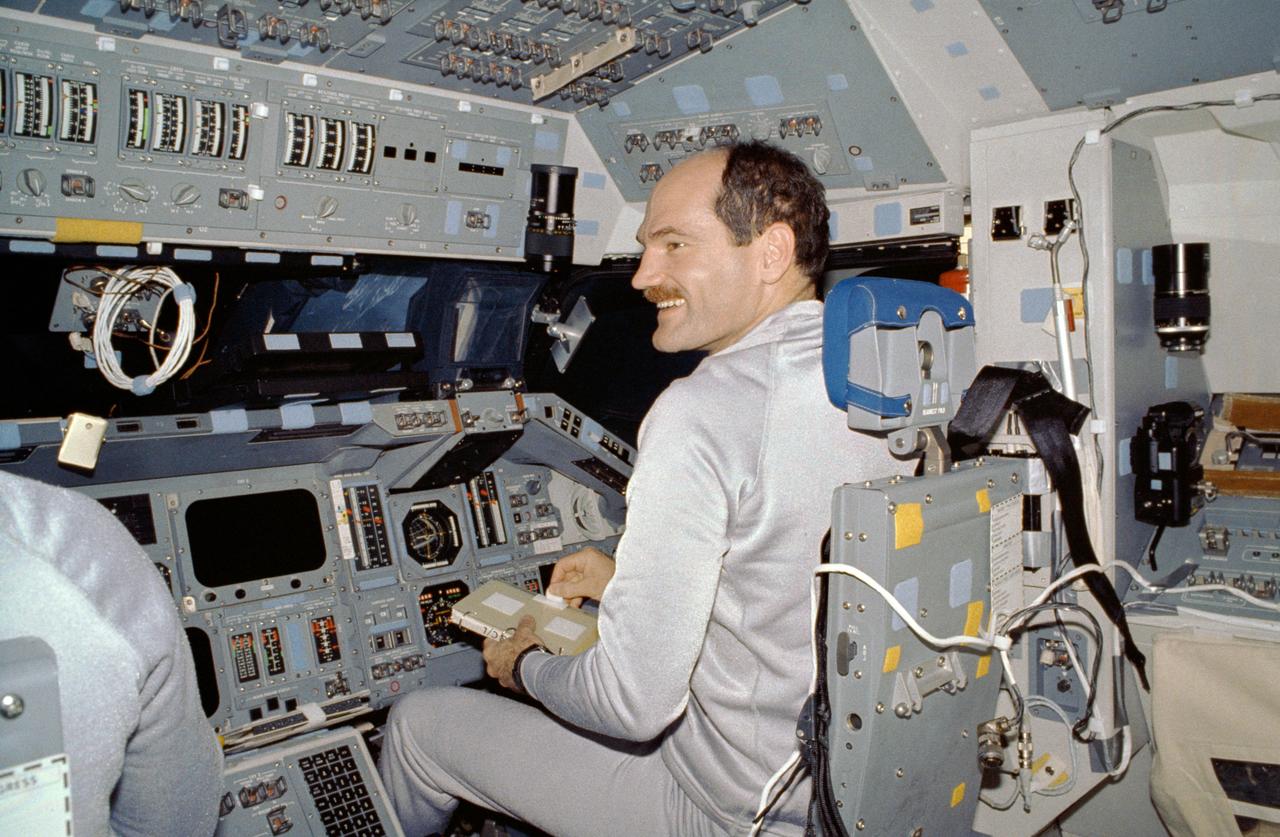 STS027-10-020a (2-6 Dec. 1988) --- Astronaut Guy S. Gardner, STS-27 pilot, converses with astronaut Robert L. Gibson (almost totally out of view at left) commander, as the two are seated at their respective stations on the flight deck of the Earth-orbiting space shuttle Atlantis. Photo credit: NASA