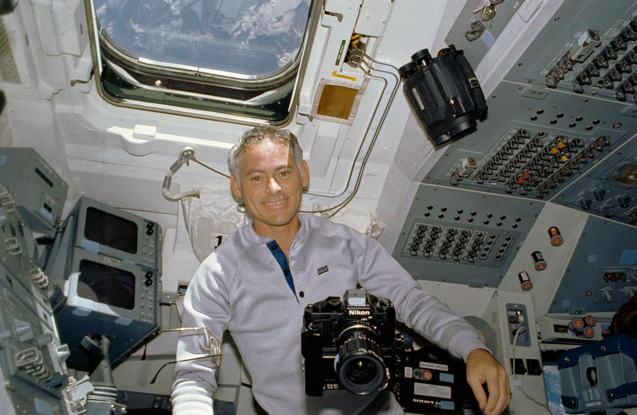 STS027-10-021 (2-6 Dec. 1988) --- Astronaut Richard M. (Mike) Mullane, STS-27 mission specialist, is able to handle a number of cameras with the aid of the microgravity in the shirt sleeve environment of the Earth-orbiting space shuttle Atlantis. Photo credit: NASA