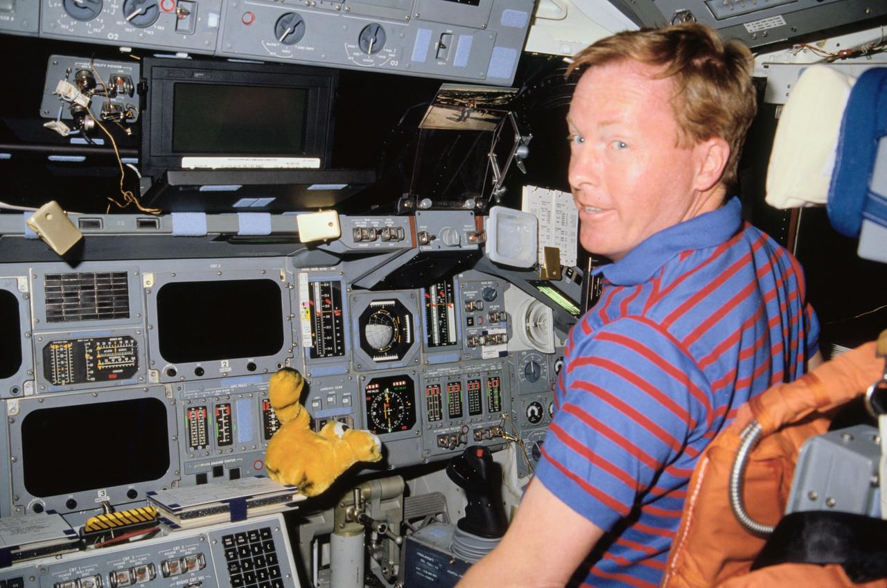 STS028-06-031 (August 1989) --- Astronaut Richard N.  Richards, pilot, is captured with a 35mm camera at the pilot's station on the flight deck of the space shuttle Columbia during the STS-28 flight.  Nearby is a tiger.  Richards is an alumnus of the University of Missouri, whose mascot is a tiger.