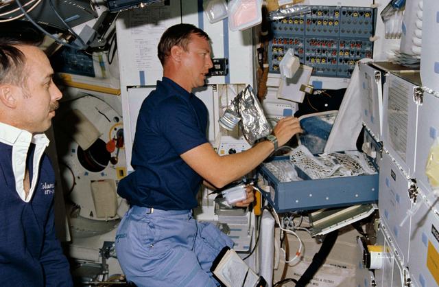 STS-28 Columbia, OV-102, MS Brown juggles food containers on middeck