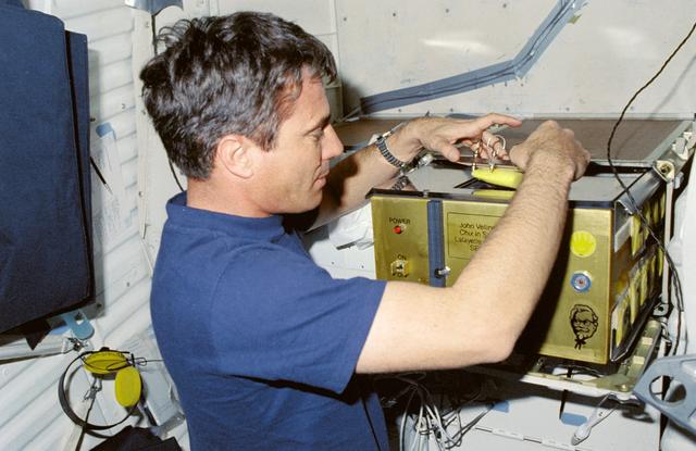 NASA image: STS-29 Pilot Blaha with SE83-9 "Chix in Space" incubator on OV-103's middeck