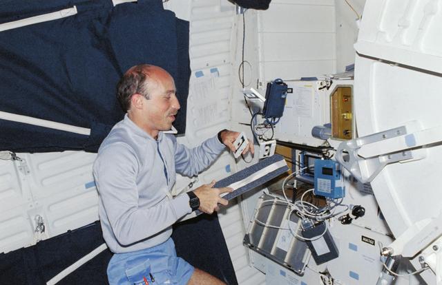 NASA image: STS-29 MS Bagian juggles audio cassettes on Discovery's, OV-103's, middeck