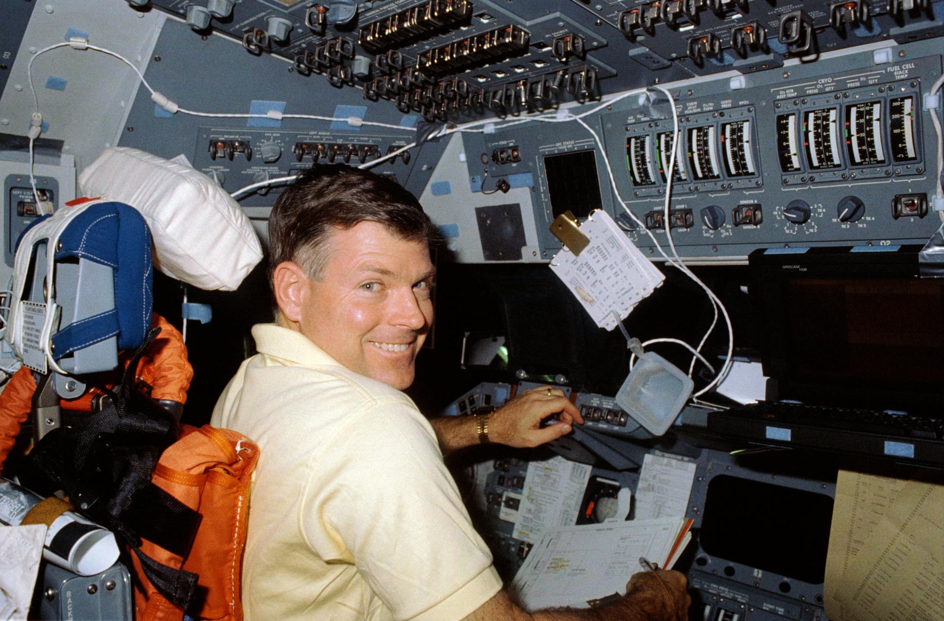Astronaut Michael L. Coats appears to like the status of the STS-29 flight as he offers a big smile from the commander's station on the flight deck