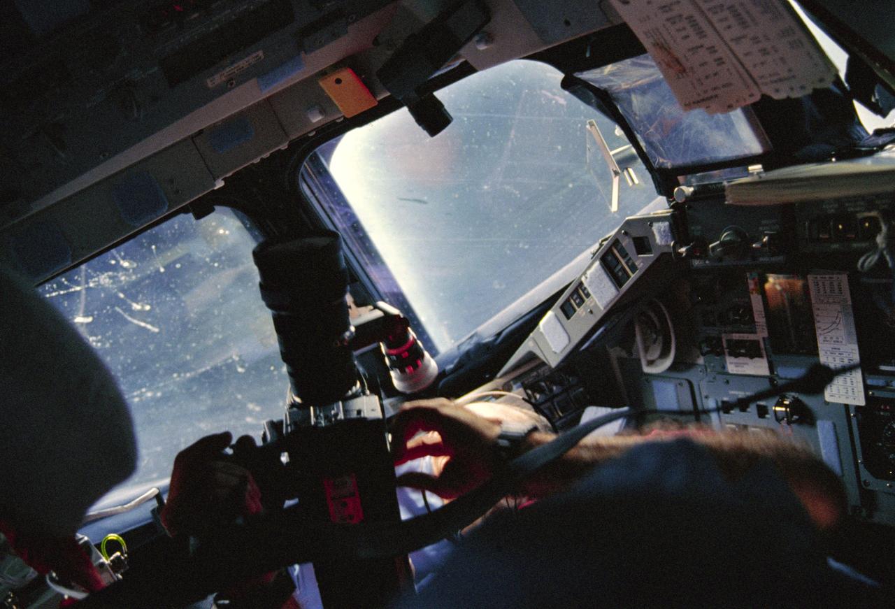 STS029-06-015 (13-18 March 1989) --- This scene of an astronaut with a camera was a common one during the five-day flight of STS-29.  Astronaut James P. Bagian, STS-29 mission specialist, aims the Arriflex motion picture camera at Earth through one of Discovery's overhead windows.  The scene was recorded with a 35mm camera.