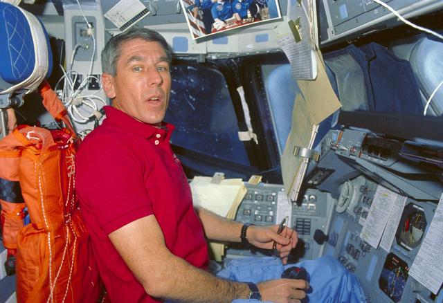 NASA image: STS-29 Pilot Blaha displays photograph of crewmembers' wives on flight deck