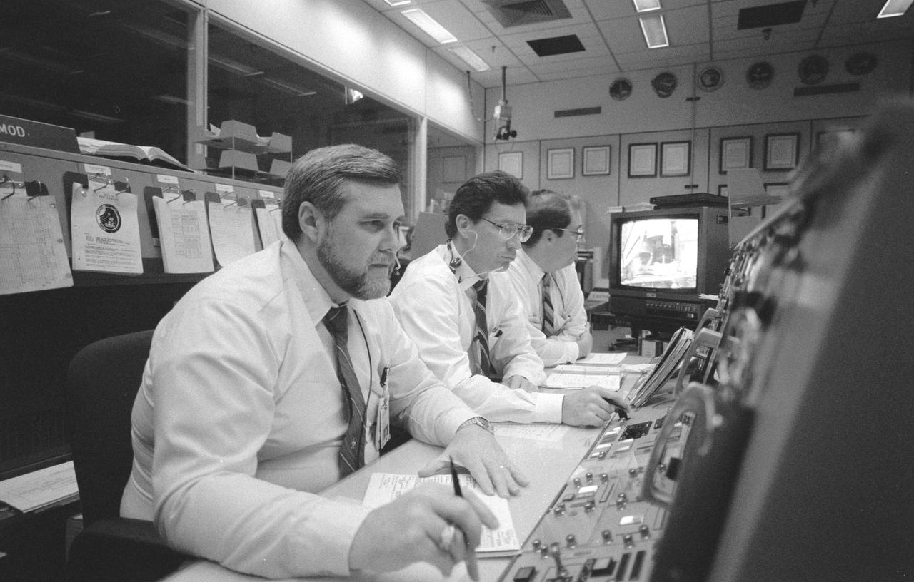 Only moments away from ignition, Atlantis, Orbiter Vehicle (OV) 104, and its five member crew are the subjects of concern drawing serious countenance in this scene in the Flight Control Room (FCR) of JSC's Mission Control Center (MCC) Bldg 30. Ascent Flight Director Alan L. Briscoe, monitors the Kennedy Space Center pre-launch activity from the flight director (FD) console, along with Ronald D. Dittemore (center) and N. Wayne Hale, Jr.
