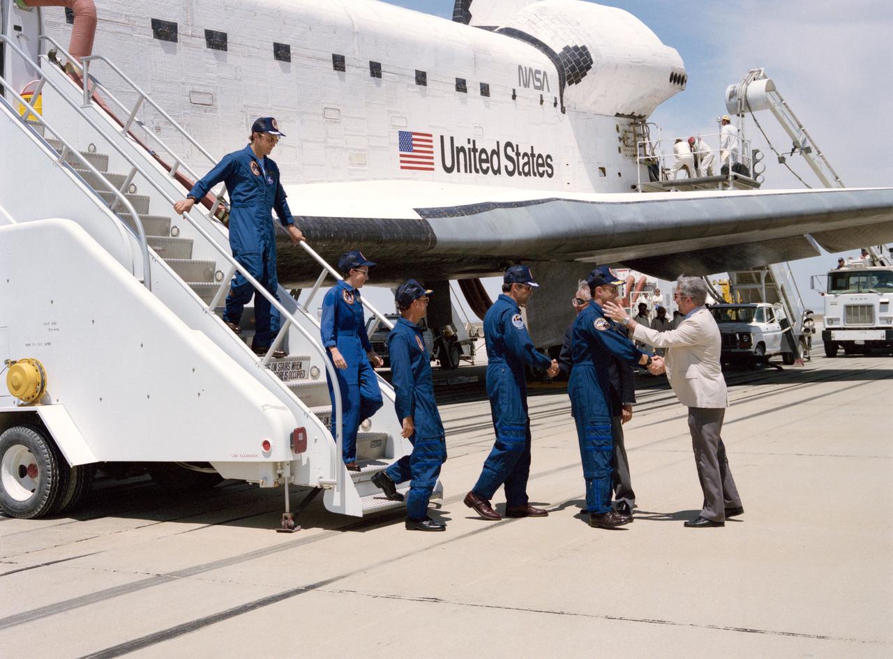 STS030-S-131 (8 May 1989) --- Crewmembers who spent just over four full days in space aboard Space Shuttle Atlantis egress their temporary home for a welcome meeting with terra firma. Astronaut David M. Walker, mission commander, shakes hands with Rear Admiral Richard H. Truly, acting NASA Administrator.  Astronaut Ronald J. Grabe (center frame), pilot, is greeted by Dale D. Myers, Deputy Administrator.  Pictured behind Grabe, from bottom of steps to top, are astronauts Norman E. Thagard, Mary L. Cleave and Mark C. Lee, all mission specialists.  Minutes earlier, the spacecraft?s landing gear came to a stop at 12:44:33 P.M. (PDT), 8 May 1989.  It landed on runway 22, a concrete facility, like a number of other NASA flights.  Still others have landed on unpaved dry lakebed stripes.