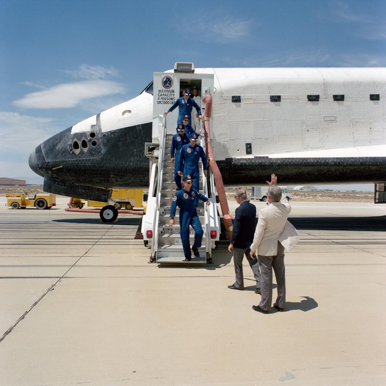 STS030-S-137 (8 May 1989) --- Crewmembers who spent four full days in space aboard Space Shuttle Atlantis egress their temporary home for a welcome meeting with terra firma. Pictured, from bottom of steps to top, are Astronauts David M.Walker, Ronald J. Grabe, Norman E. Thagard, Mary L. Cleave and Mark C. Lee. Rear Admiral Richard H. Truly (foreground), acting NASA Administrator, and Dale D. Myers, Deputy Administrator of NASA, await to greet the crewmembers.  Minutes earlier, the spacecraft's landing gear came to a stop at 12:44:33 p.m. (PDT), 8 May 1989.  It landed on Runway 22, a concrete facility, like a number of other NASA flights.  Still others have landed on unpaved dry lake bed strips.
