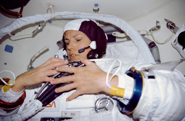 STS-31 Mission Specialist (MS) Sullivan dons EMU in OV-103's airlock