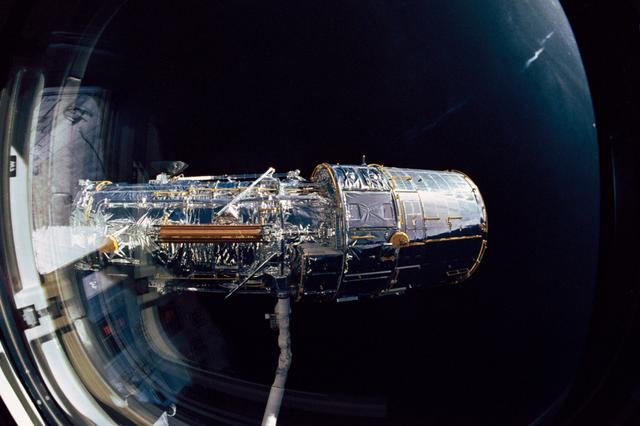 Hubble Space Telescope (HST) grappled by OV-103's RMS during STS-31 checkout