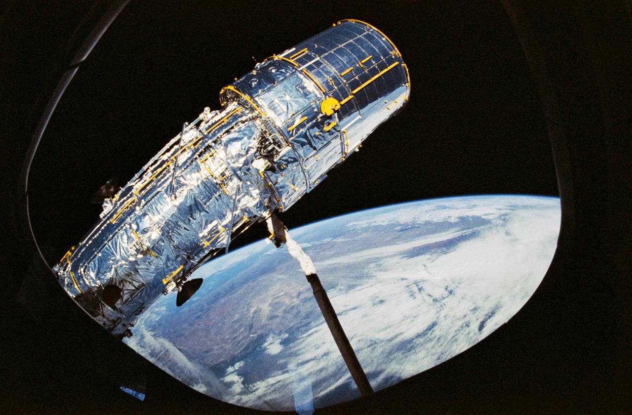 STS031-10-023 (25 April 1990) --- View of the Hubble Space Telescope (HST) on the end of Discovery's Remote Manipulator System (RMS) arm prior to deployment of its antennae and solar array panels.