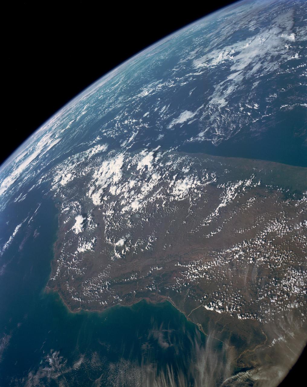 This high oblique view shows the majority of the island of Madagascar (19.0S, 47.5E). This Texas sized island is now largely deforested and is suffering from severe soil erosion as well as a declining biological species diversity and productivity. At the turn of the century, the island was almost totally forested but now, forests cover only about 10 percent of the surface. Evidence of soil erosion can be seen in the offshore sediment plumes.