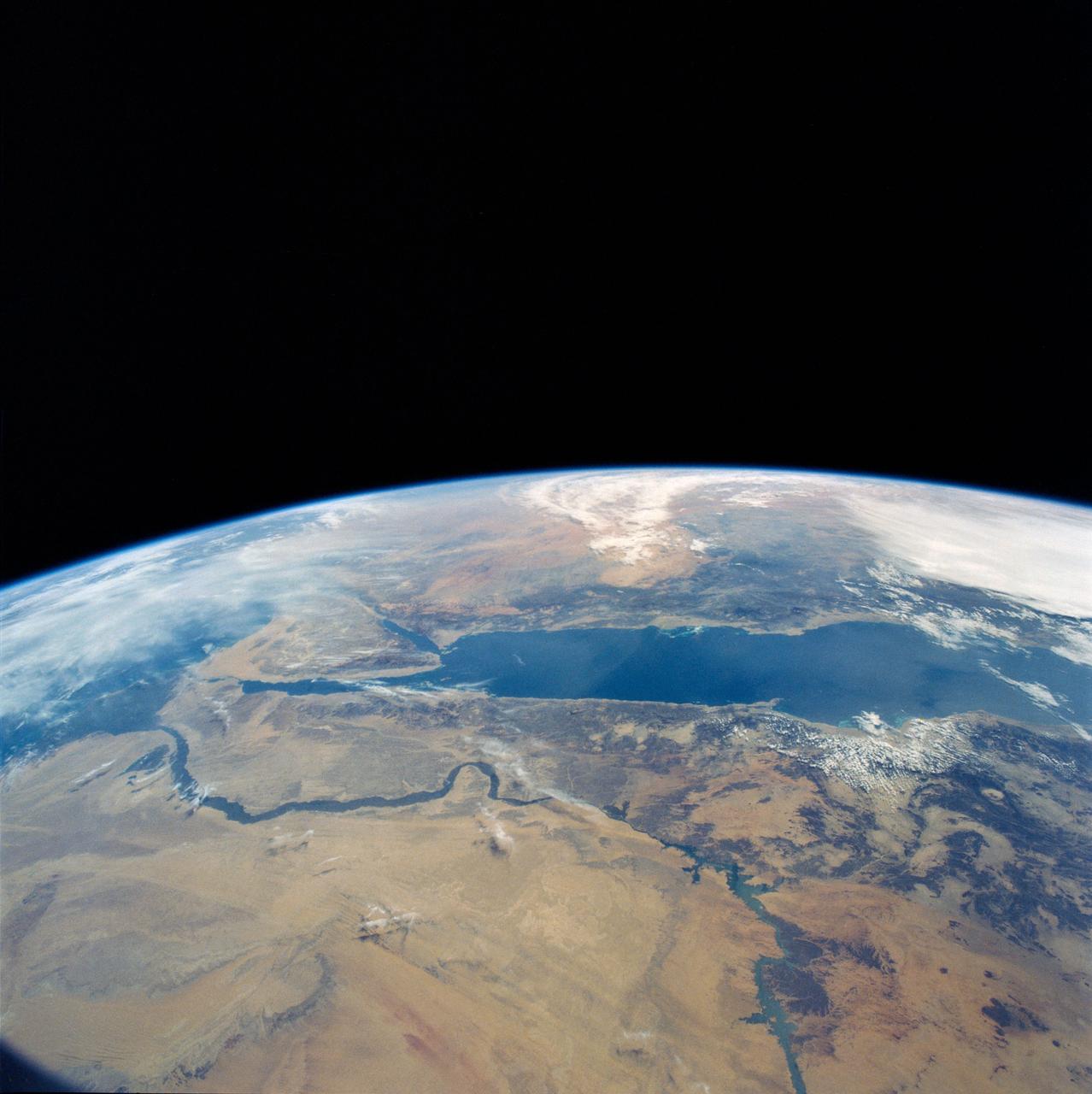 STS031-79-015 (24-29 April 1990)  --- The 330-plus nautical mile orbital altitude of the Space Shuttle Discovery allowed for this unique high oblique 70mm Hasselblad frame.  Egypt is in the foreground, with the Nile River and Lake Nasser readily identifiable.  Cairo and Alexandria are visible.  The Mediterranean Sea is on the horizon in upper left.  The Red Sea is in the center.  Other areas seen include Saudi Arabia, Jordan, Palestine and Israel; the Gulf of Aqaba and the Gulf of Suez.