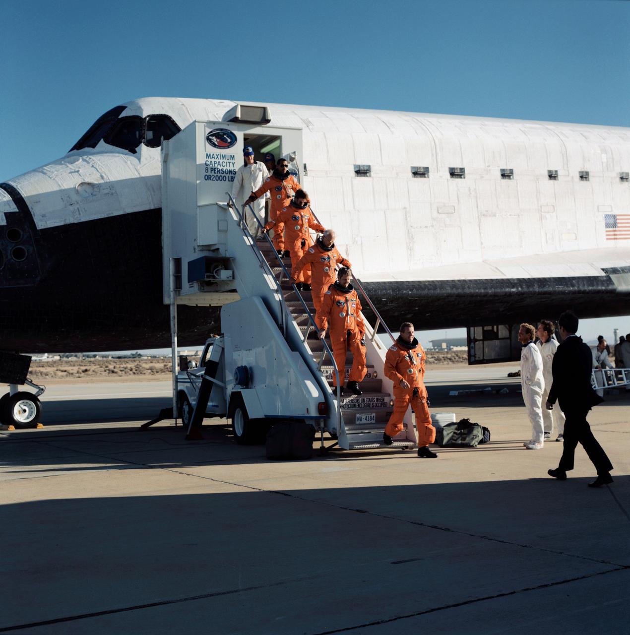 STS031-S-129 (29 April 1990) --- The astronauts of STS-31 egress the Space Shuttle Discovery following a smooth landing on the runway at Edwards Air Force Base to complete a highly successful five-day mission.  Approaching from the far right to greet the crew is Dr. William B. Lenoir, NASA's Acting Associate Administrator for Space Flight.  Leading the way down the steps is astronaut Loren J. Shriver, mission commander, followed by (in order from bottom of steps) astronauts Steven A. Hawley, Bruce McCandless II and Kathryn D. Sullivan, all mission specialists; and Charles F. Bolden Jr., pilot.  Theirs was an Earth-orbital flight during which the Hubble Space Telescope (HST) was sent toward its 15-year mission.