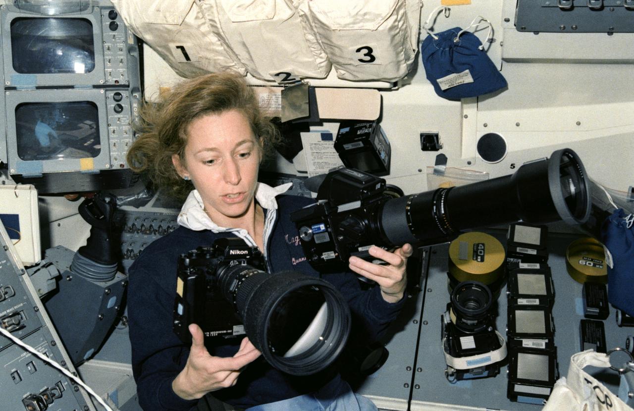 STS032-15-022 (9-20 Jan 1990)  --- A 35mm scene of Astronaut Marsha S. Ivins with 35mm and 70mm cameras and accessories on Columbia's aft flight deck. The photo depicts the role photography played on the record-setting 11-day STS-32 mission.