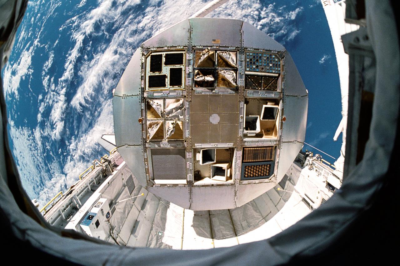 STS032-541-018 (12 Jan 1990) --- One of a number of frames photographed by the STS-32 crew as part of a detailed supplementary objective on documentary still photography.  The DSO was monitored by Astronaut Marsha S. Ivins, mission specialist.  STS032-541-018 Kodak Ektar 25 negative film.  35mm frame of LDEF suspended just over its resting place in cargo bay.  White clouds and blue ocean in foreground.