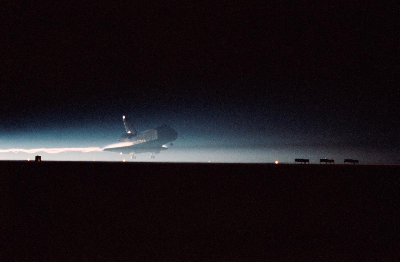 STS-32 Columbia, Orbiter Vehicle (OV) 102, is captured as its main landing gear (MLG) touches down on runway 22 at Edwards Air Force Base (EAFB), California, in the early morning darkness. The night landing ended a record 11-day mission in space. Moments later, at 1:36:38 am Pacific Standard Time (PST), OV-102 came to a complete stop, having logged 4,509,972 miles in flight.