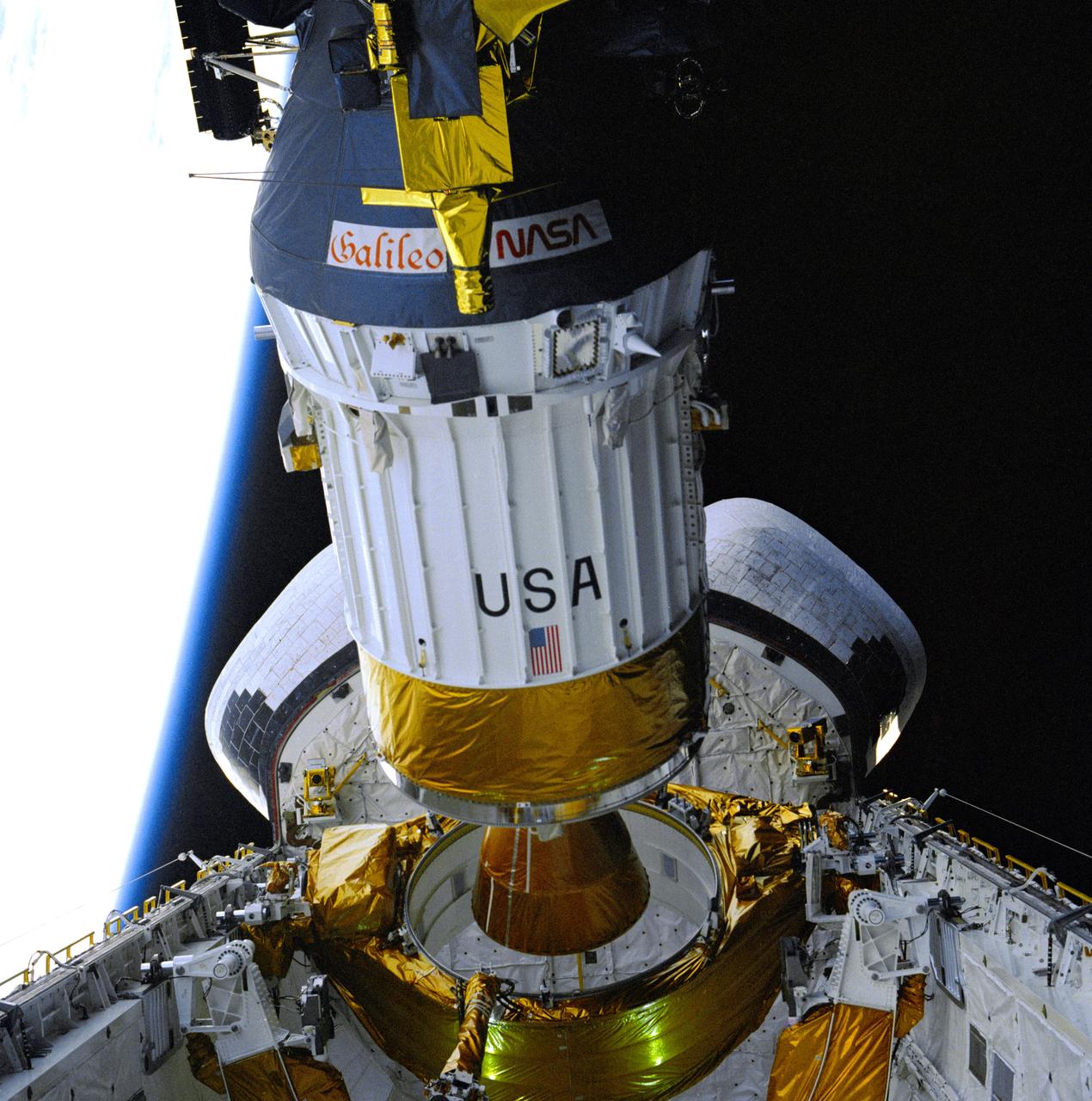 STS034-71-000AK (18 Oct 1989) --- Backdropped against the blackness of space, the Galileo spacecraft and its inertial upper stage (IUS) have just detached from a cradle-like device aboard the Earth-orbiting Space Shuttle Atlantis to begin a six-year journey to Jupiter.  The five-member STS-34 crew deployed the satellite within six hours of achieving Earth orbit on Oct. 18, 1989.  The scene was exposed with a 70mm handheld Hasselblad camera.  Earth's horizon and a thin line representing its airglow and atmosphere are visible on the left side of the frame.