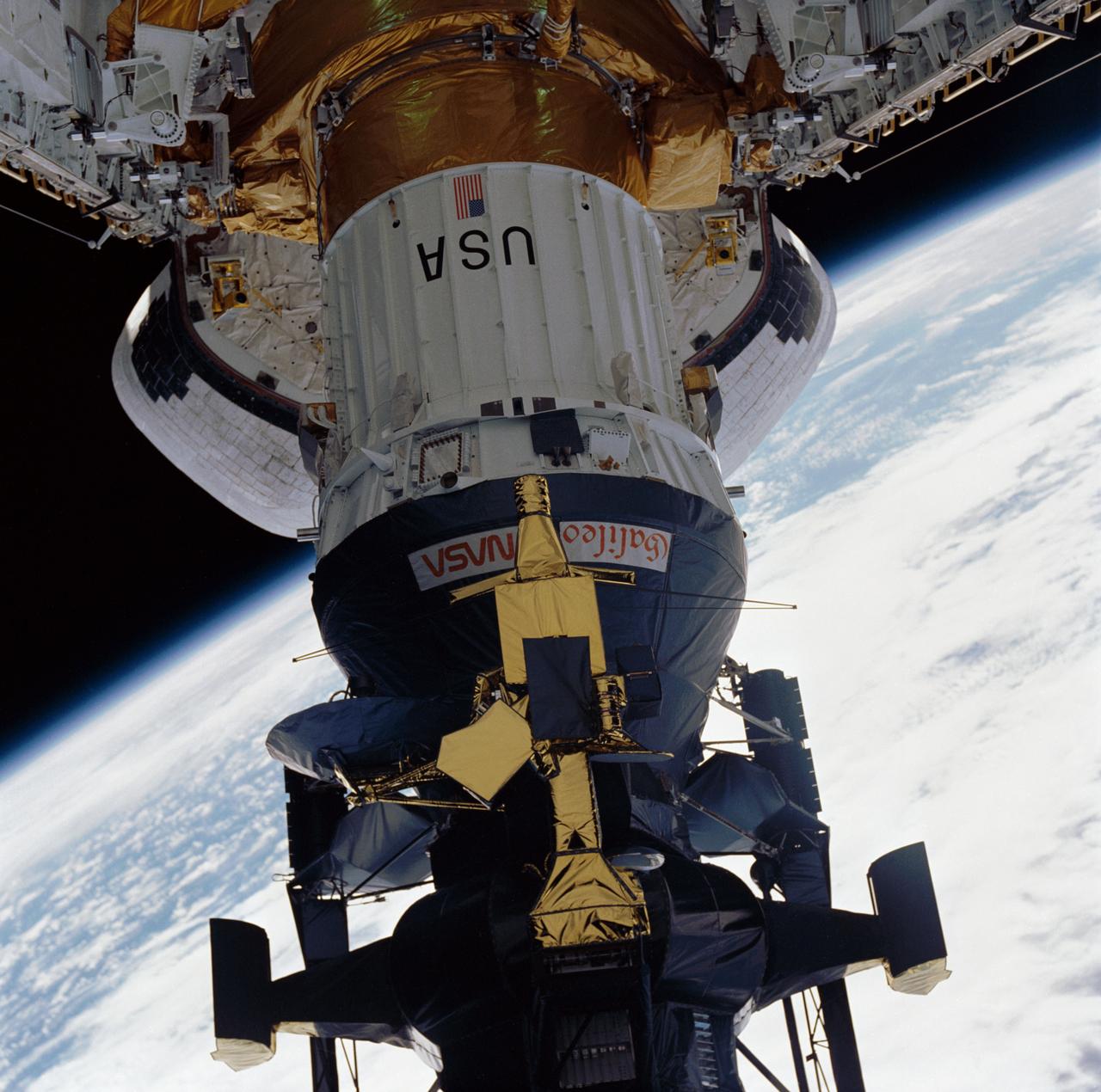 During STS-34 mission, the Galileo spacecraft mounted atop the inertial upper stage (IUS) is tilted to a 58-degree deployment position by the airborne support equipment (ASE) aft frame tilt actuator (AFTA) table in Atlantis', Orbiter Vehicle (OV) 104's, payload bay (PLB). Visible in the foreground is the ASE forward cradle and the umbilical boom which has fallen away from the IUS. OV-104's orbital maneuvering system (OMS) pods and the Earth's limb appear in the background.