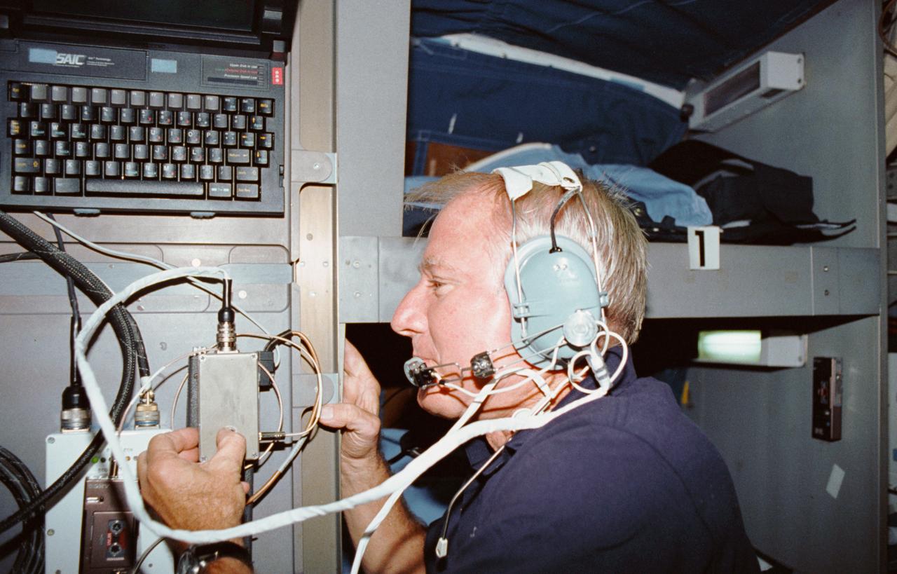 STS035-05-036 (2-10 Dec 1990) --- STS-35 Commander Vance D. Brand, wearing headset, communicates with family members using Shuttle Amateur Radio Experiment (SAREX) on Columbia's, Orbiter Vehicle (OV) 102's, middeck. SAREX and its portable laptop computer mounted on the outside of the middeck sleep station allowed the STS-35 crewmembers to "visit" and briefly share some of their in space experiences with family members. It also provided radio transmissions between ground based amateur radio operators around the world and OV-102. The experiment enabled students from all over the United States to have a chance to communicate with a crewmember in space.