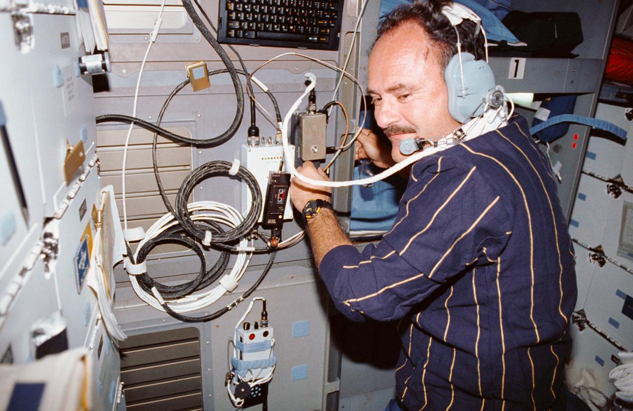 STS035-15-010 (2-11 Dec 1990) --- Astronaut John M. (Mike) Lounge, STS-35 mission specialist, communicates with family members from the middeck of Space Shuttle Columbia in Earth orbit.  The STS-35 Shuttle amateur radio experiment (SAREX), allowed the Astro 1 crewmembers to "visit" and briefly share some of their in space experiences with family members.  The picture was made with a 35mm camera.                           Note: Used by Astronomer Ronald A. Parise on his off-duty hours,  SAREX provided radio transmissions between ground based amateur radio operators around the world and the Shuttle. Parise is a payload specialist who is also a licensed amateur radio operator (call-sign WA4SIR).  The experiment enabled students from all over the United States to have a chance to communicate with an astronaut in space.
