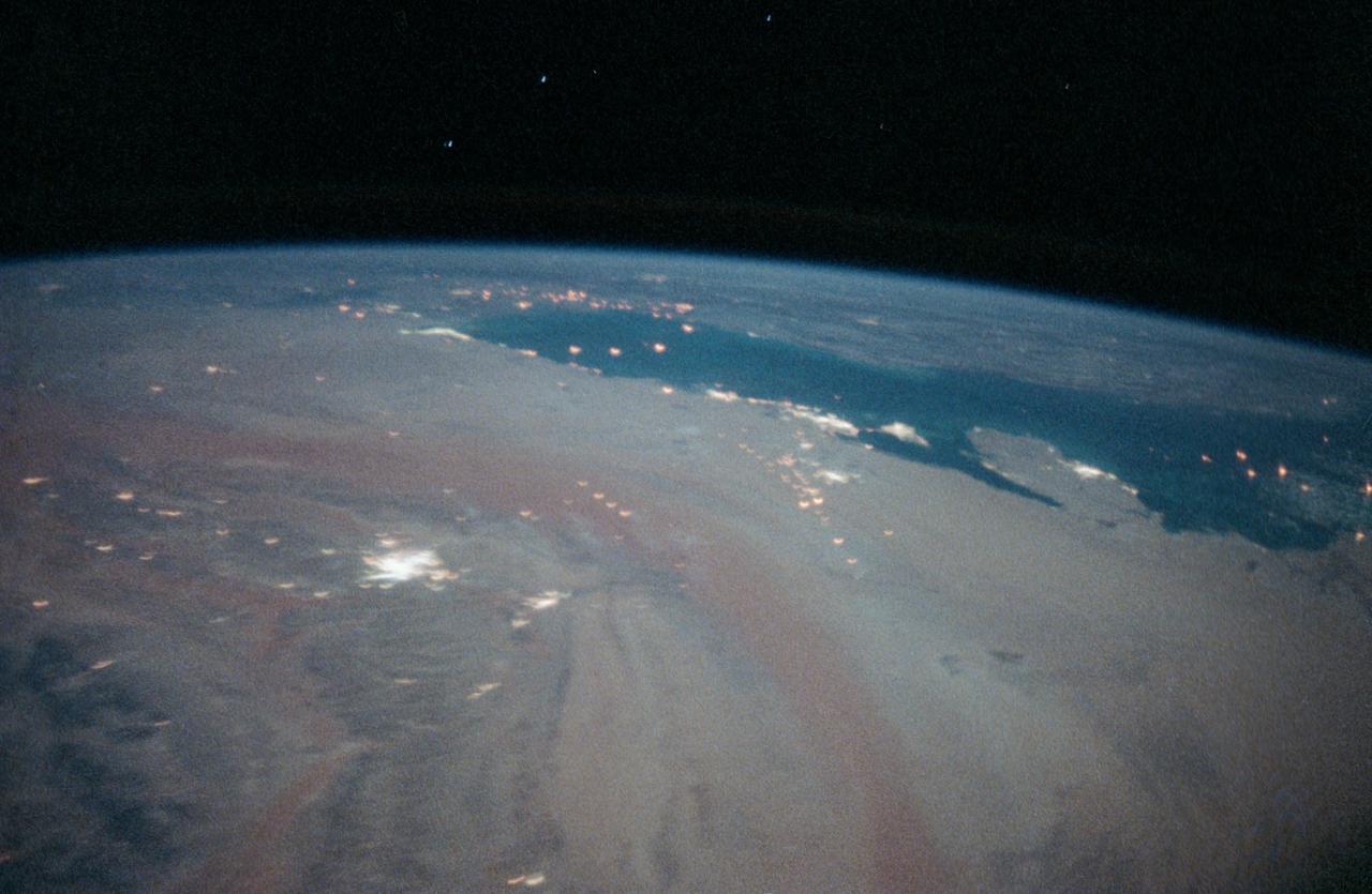 STS-35 Earth observation taken aboard Columbia, Orbiter Vehicle (OV) 102, is of the Persian Gulf area. Major cities and oilfields of the countries of Saudi Arabia (foreground), Iraq (top left), Iran (top center and top right), Kuwait, Bahrain, Qatar, and a portion of the United Arab Emirates are visible in this scene. The cities are the large whitish areas of city lights. Flares characteristic of the Mid-East oil field practices are visible both onshore and offshore throughout the scene. Major cities identifiable are in Iraq - Baghdad, Basra, and Faw; in Qatar - Ab Dawhah; in Kuwait - Kuwait City; in Saudi Arabia - Riyadh, Al Jubayl, Dharan, Al Huf, Ad Dilam and Al Hariq; and Bahrain and its associated causeway to the mainland.