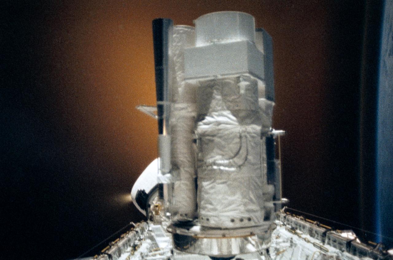 STS035-28-006 (2-10 Dec 1990) --- STS-35 Astronomy Laboratory 1 (ASTRO-1) telescopes, in on-orbit operating position in the payload bay (PLB), are silhouetted against an reaction control system (RCS) right thruster firing. Three ultraviolet telescopes are mounted and precisely co-aligned on a common structure, called the cruciform, that is attached to the instrument pointing system (IPS). Here the IPS holds the telescopes in a position that is parallel to the Earth's limb below. Visible on the cruciform are the star tracker (S TRK) (silver cone at the top), the Ultraviolet Imaging Telescope (UIT) (behind S TRK), and the Hopkins Ultraviolet Telescope(HUT).