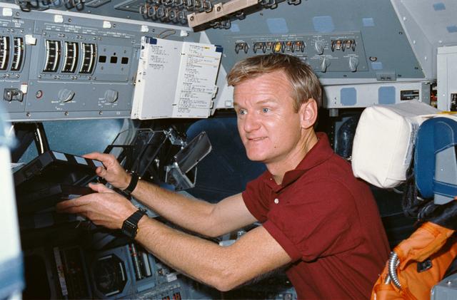 NASA image: STS-36 Pilot Casper reaches for laptop computer on OV-104's flight deck
