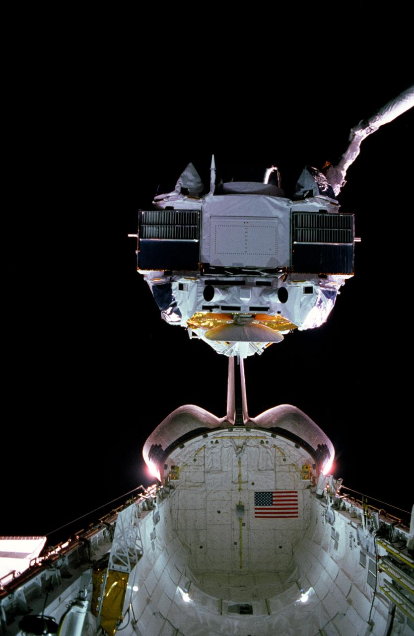 STS037-03-033 (7 April 1991) --- The Gamma Ray Observatory (GRO) is held above Atlantis' cargo bay, backdropped against dark space. The large observatory's solar panels and high-gain antenna are not deployed in this early scene. An emergency extravehicular activity (EVA) was later required to manually deploy the high-gain antenna. The 35mm frame was photographed through Atlantis' aft flight deck windows.