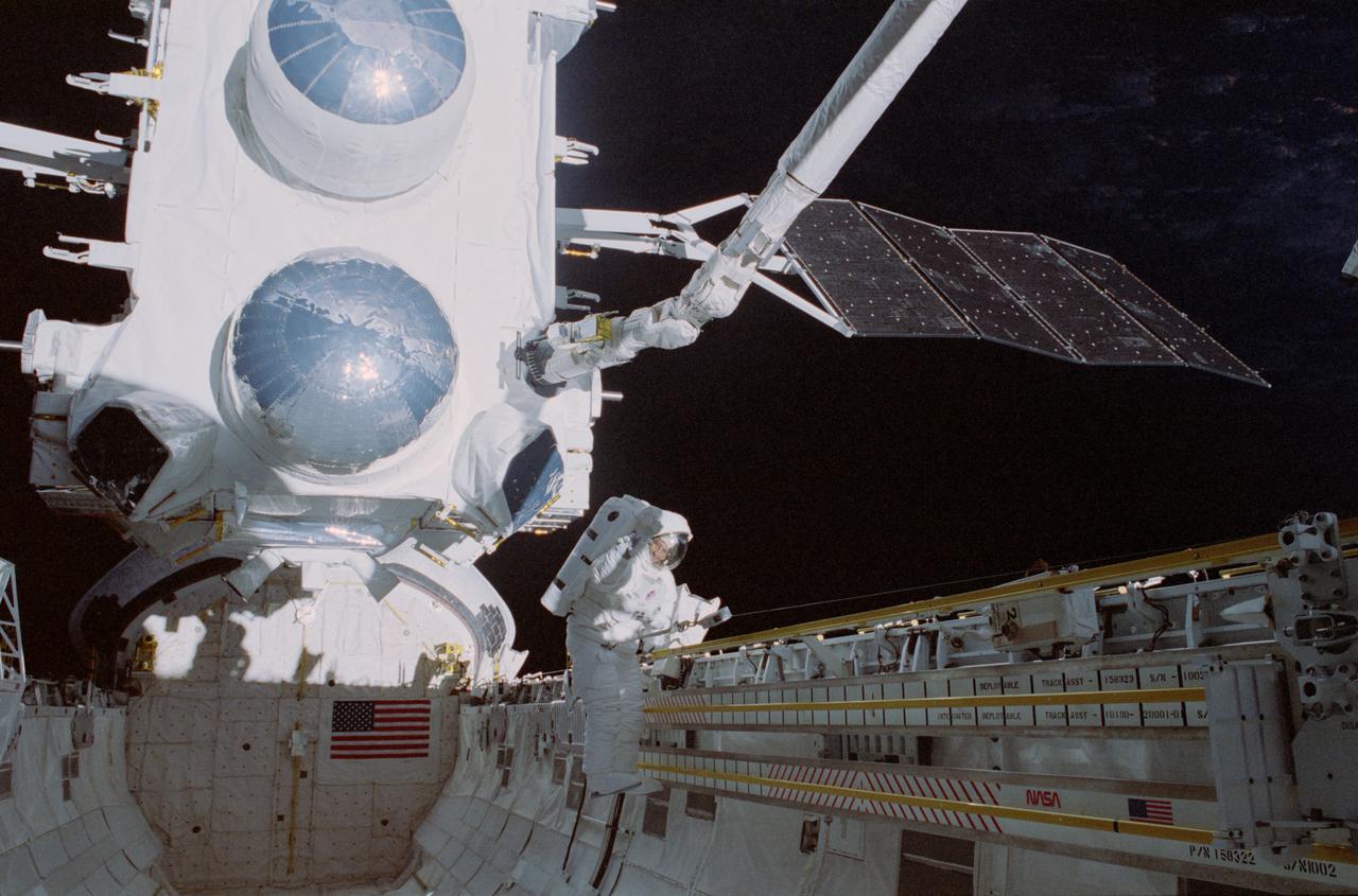 Photographic documentation showing activities in the payload bay of the orbiter Atlantis during STS-37. View include: Gamma Ray Observatory (GRO) on end of Remote Manipulator System (RMS), with Mission Specialist Jay Apt below on the port side of the payload bay.