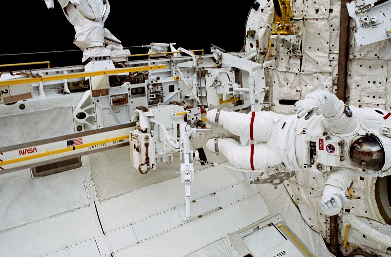 S37-52-008 (April 1999)  --- STS-37 Mission Specialist Jerry L. Ross, attired in an extravehicular mobility unit (EMU) with red stripes, can be seen with the crew and equipment transport aid (CETA) just below the base of the remote manipulator system arm on the port side of the payload bay of the space shuttle Atlantis. Photo credit: NASA